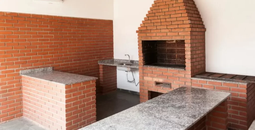 Churrasqueira de tijolos em espaço aberto, representando o calor das conversas difíceis.