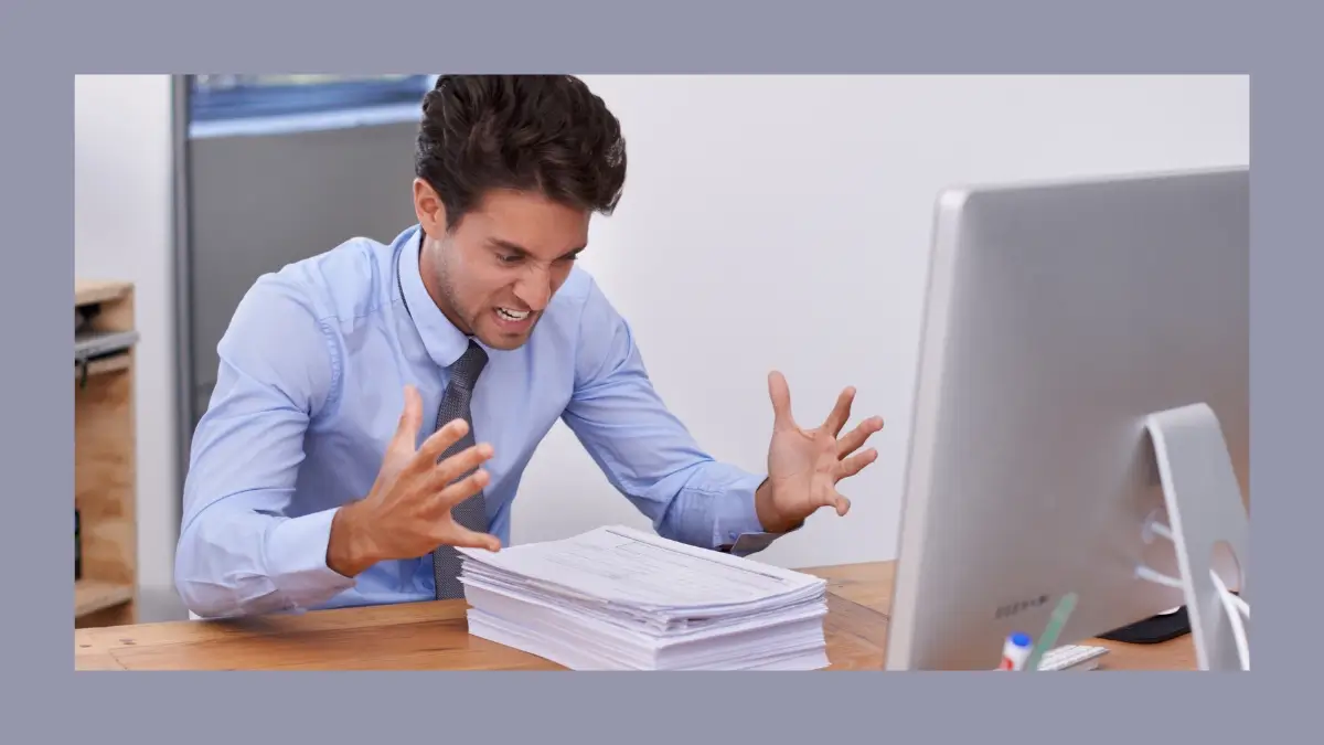 Homem frustrado diante do computador, representando a pressão de sempre ter que ser suficiente.