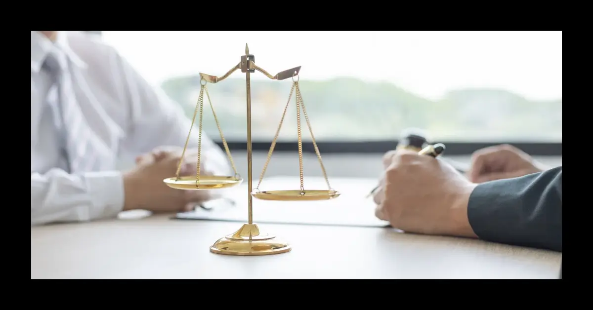 Mãos apoiadas sobre uma mesa com uma balança da justiça dourada ao centro, simbolizando direitos e regras de convivência no CoHerência.