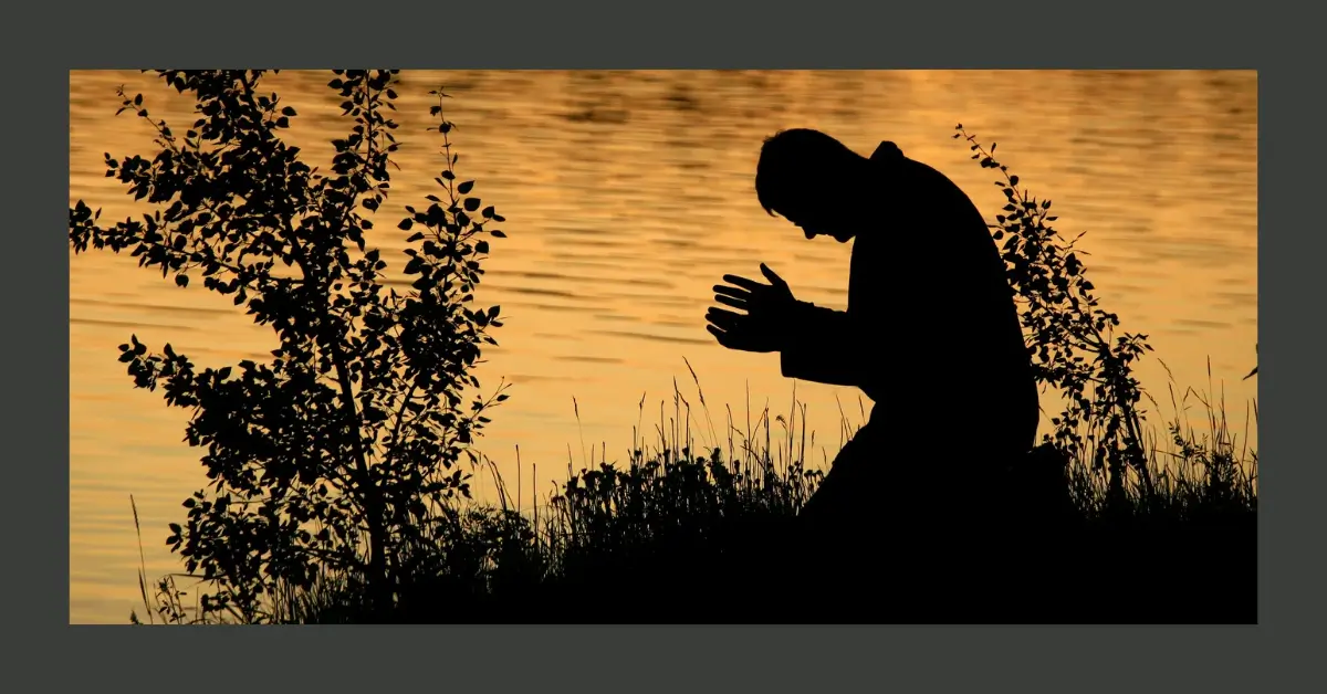 Pessoa ajoelhada ao pôr do sol, simbolizando um momento de oração de transformação.