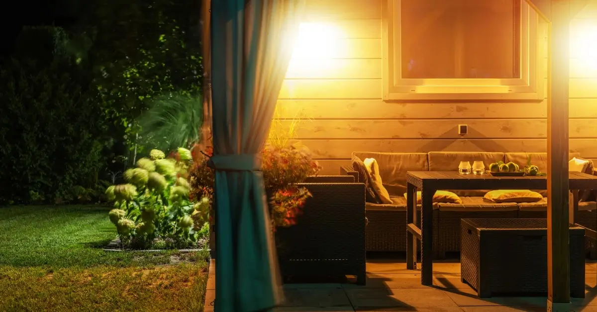 Varanda iluminada à noite com sofás e mesa, simbolizando acolhimento e chegada no CoHerência.